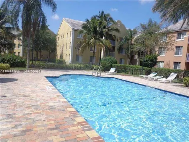 a palm tree sitting in front of a house with a yard