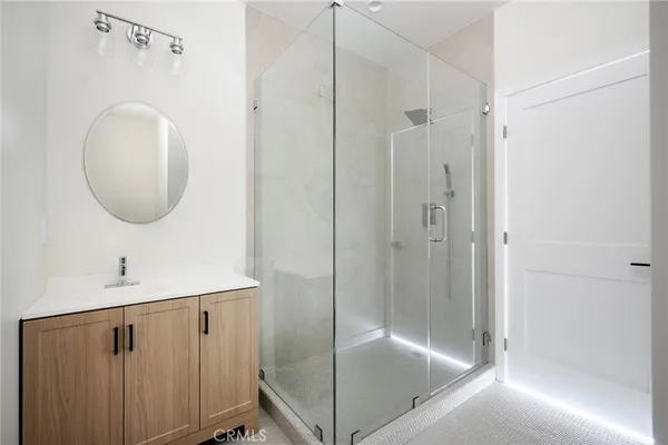 a bathroom with a shower a mirror and a sink