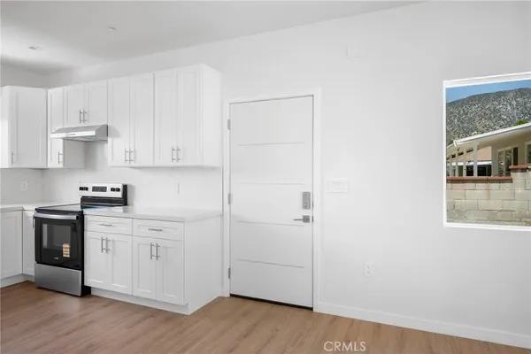 a kitchen with stainless steel appliances granite countertop white cabinets and wooden floor