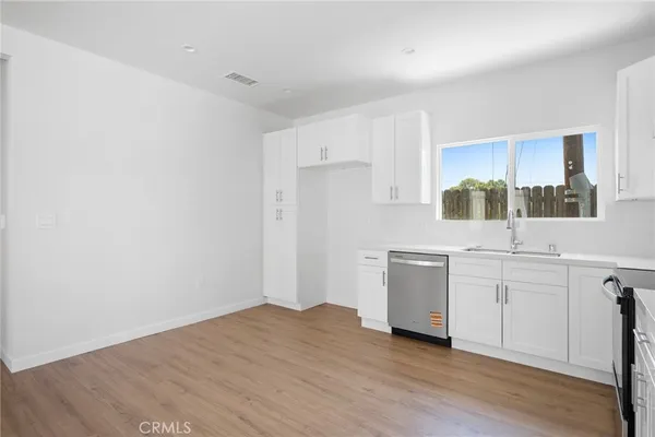 a kitchen with white cabinets and white appliances