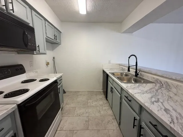 a kitchen with a sink stove and microwave