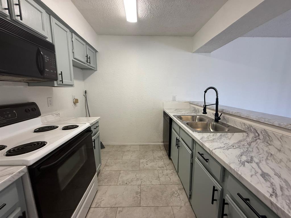 9813 Walnut Street, Unit 302 Dallas, TX 75243 - Photo 4 of 7 a kitchen with a sink stove and microwave