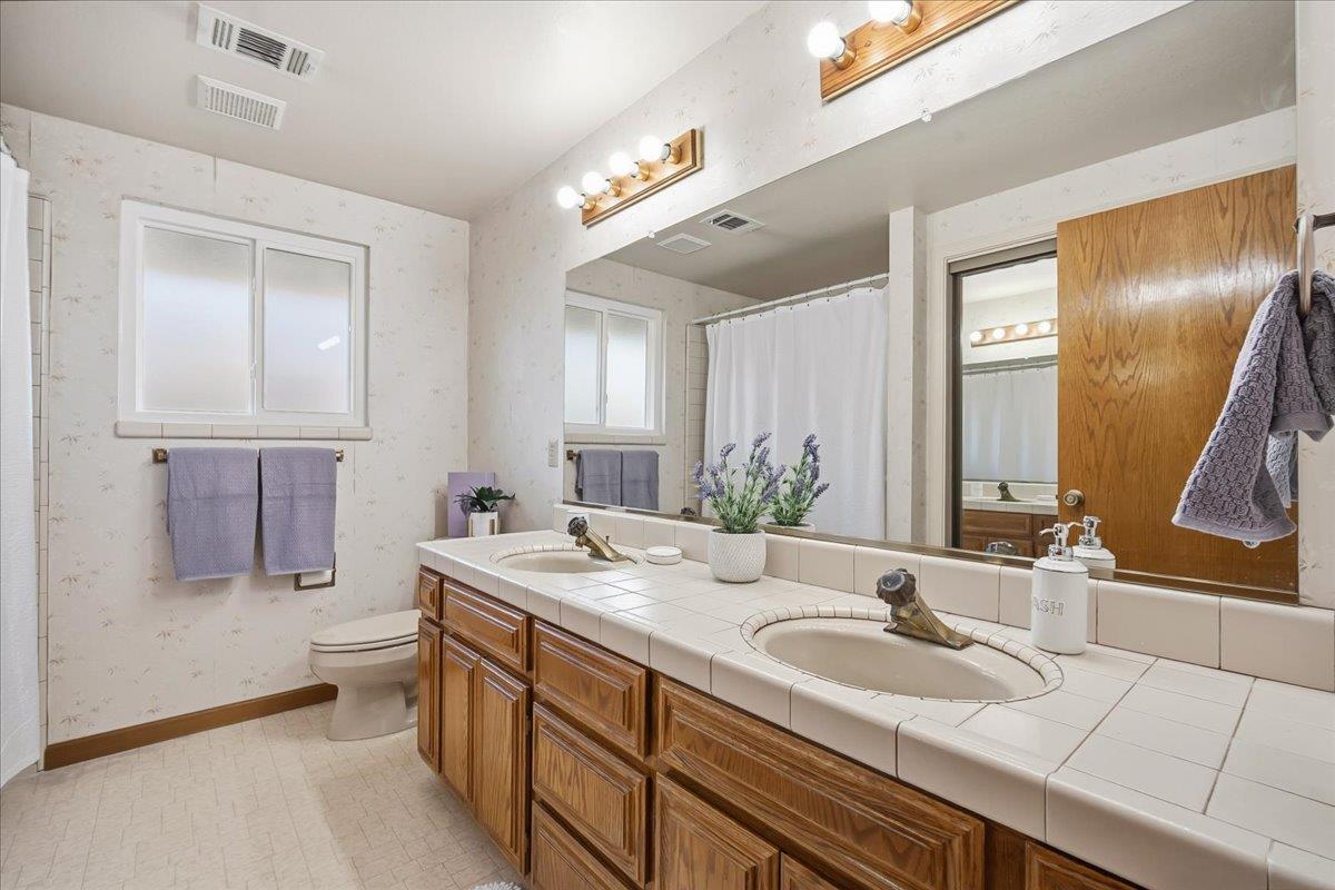 363 Diamond Oaks Road Roseville, CA 95678 - Photo 31 of 51 Classic main bath offering dual-sink convenience, a classic tub-and-shower combination, window to let in natural light and dedicated utility closet with full length sliding mirror doors.