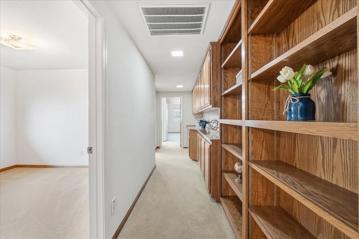 363 Diamond Oaks Road Roseville, CA 95678 - Photo 32 of 51 An impressive gallery hall featuring a custom built-in library book shelves and integrated cabinetry for seamless organization.