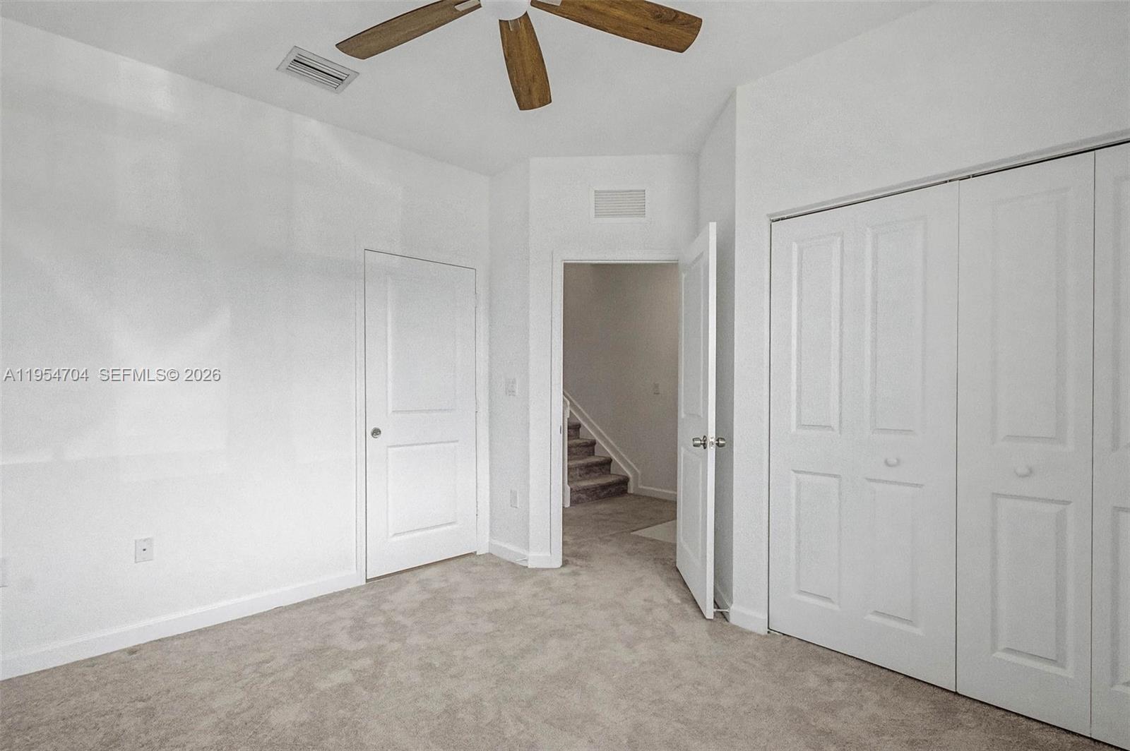 12947 Southwest 234th Street Homestead, FL 33032 - Photo 13 of 33 an empty room with a hallway and a chandelier fan