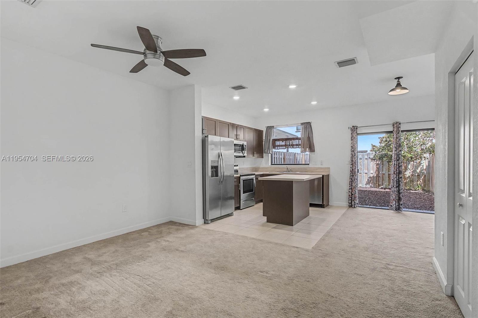 12947 Southwest 234th Street Homestead, FL 33032 - Photo 7 of 33 a view of a kitchen with a sink and dishwasher a refrigerator with wooden floor