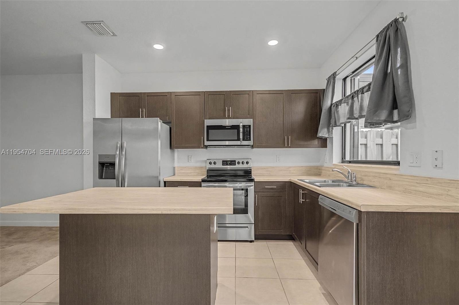 12947 Southwest 234th Street Homestead, FL 33032 - Photo 10 of 33 a kitchen with stainless steel appliances granite countertop a sink stove and refrigerator