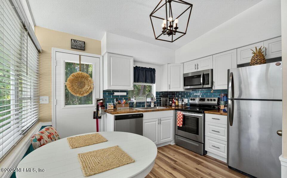 119 Ludwig Avenue Crescent City, FL 32112 - Photo 13 of 31 a kitchen with stainless steel appliances granite countertop a refrigerator a stove a sink dishwasher a dining table and chairs with wooden floor