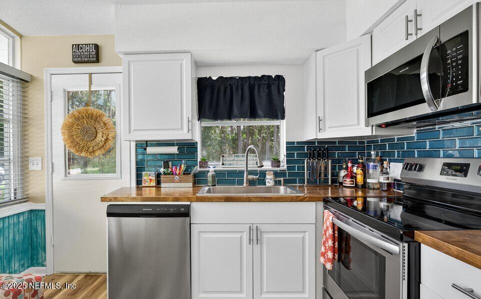 119 Ludwig Avenue Crescent City, FL 32112 - Photo 15 of 31 a kitchen with stainless steel appliances kitchen island granite countertop a stove a sink and a microwave