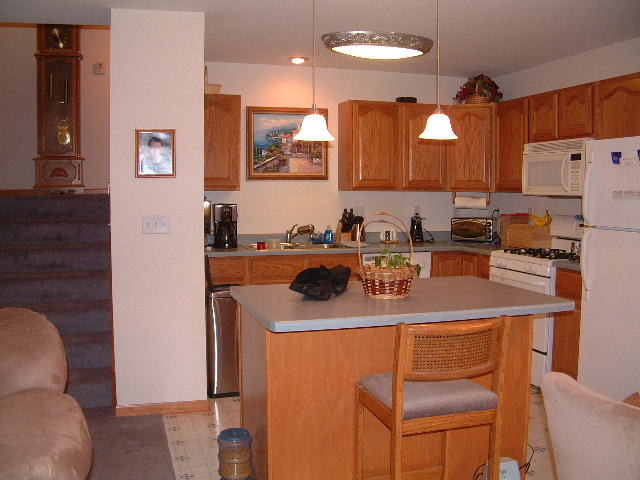 550 South Peace Road, Unit 550 Sycamore, IL 60178 - Photo 3 of 12 a kitchen with stainless steel appliances a sink a stove a refrigerator cabinets and dining table