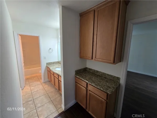a kitchen with granite countertop a sink stove and cabinets