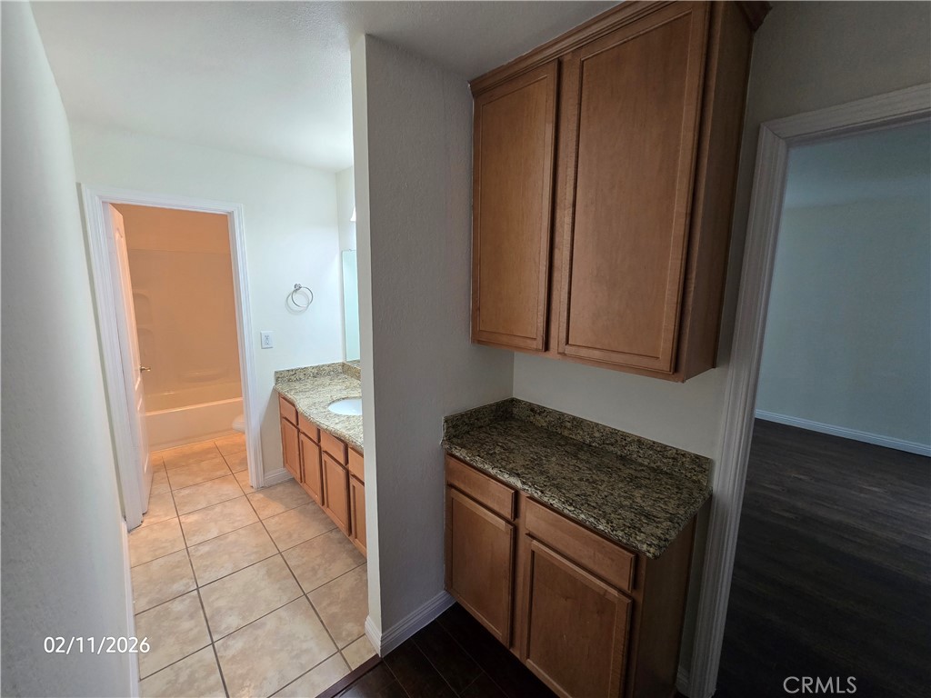 1345 Cabrillo Park, Unit R03 Santa Ana, CA 92701 - Photo 12 of 21 a kitchen with granite countertop a sink stove and cabinets