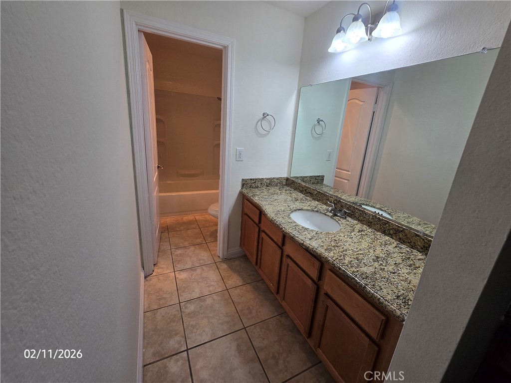 1345 Cabrillo Park, Unit R03 Santa Ana, CA 92701 - Photo 13 of 21 a bathroom with a granite countertop sink and a mirror