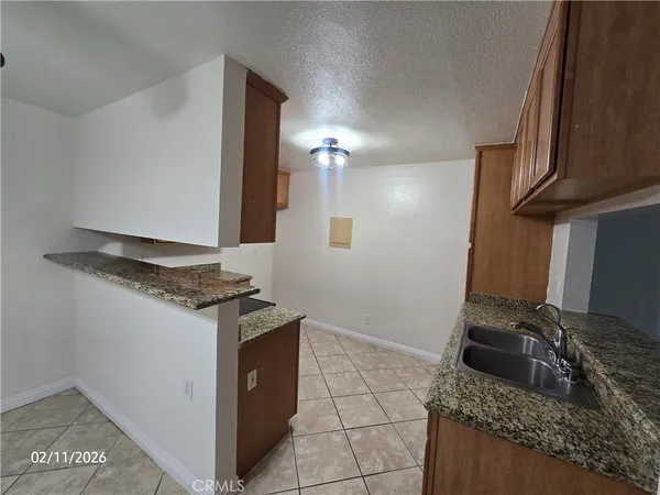 a kitchen with granite countertop a sink stove and cabinets