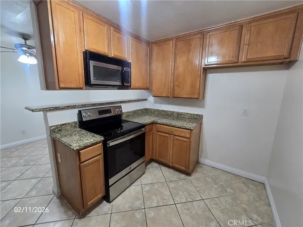 a kitchen with granite countertop a stove and a microwave