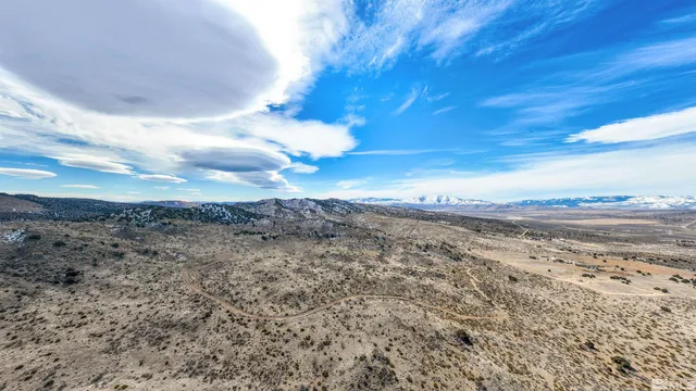 a view of a dry yard with wooden fence