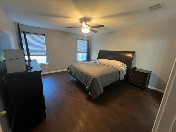 a spacious bedroom with a bed and a chandelier