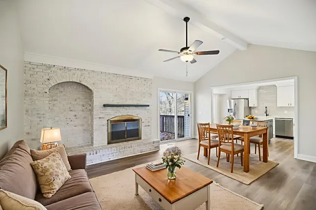 a living room with furniture a fireplace and a chandelier