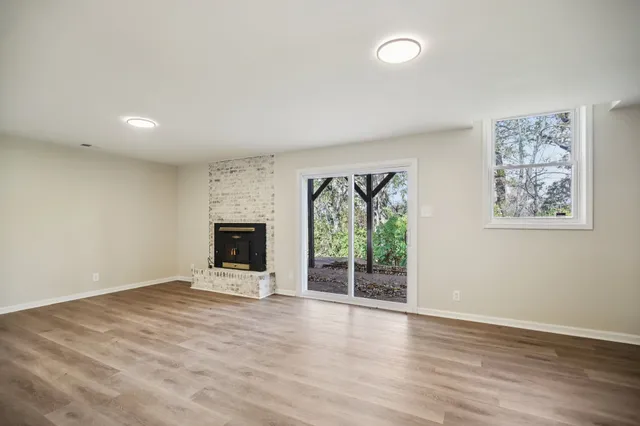 a view of an empty room with a fireplace and a window