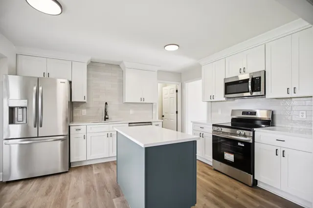 a kitchen with a white cabinets and stainless steel appliances