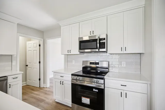 a kitchen with stainless steel appliances a stove a microwave and cabinets