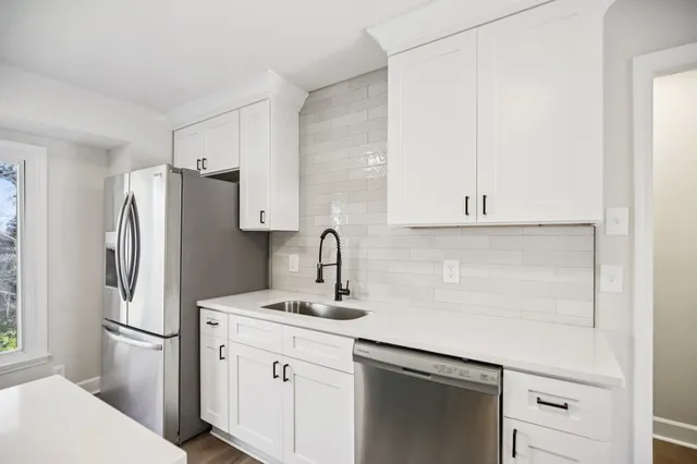 a kitchen with a refrigerator sink and cabinets