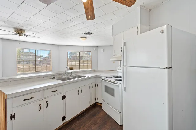 a kitchen with white cabinets and white appliances
