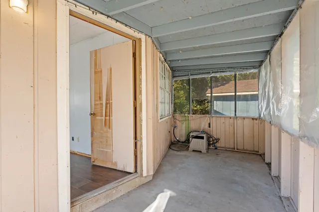 a view of a room that has a large window and furniture