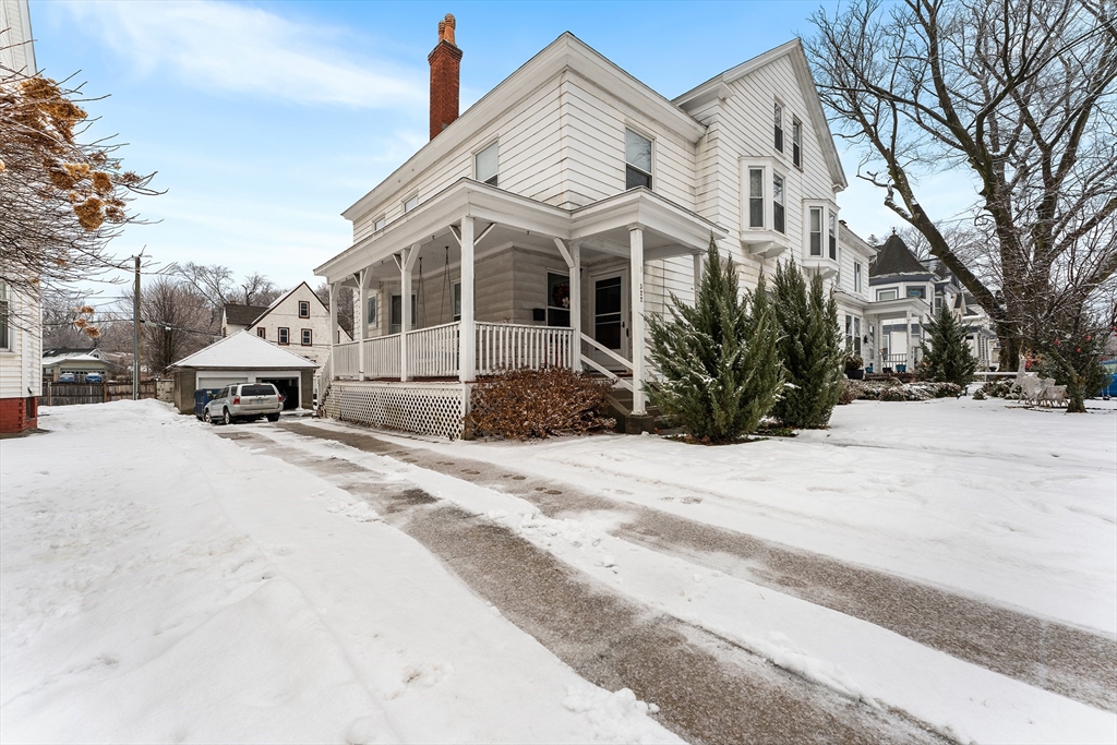 a view of a white house with a snow on the road