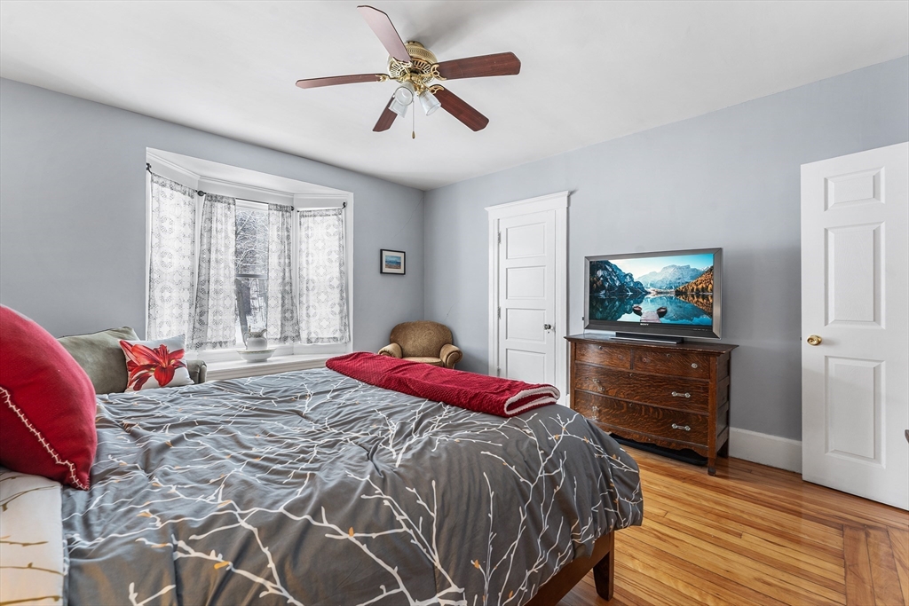 322 Highland Street Worcester, MA 01602 - Photo 14 of 29 a bedroom with a bed and a chandelier