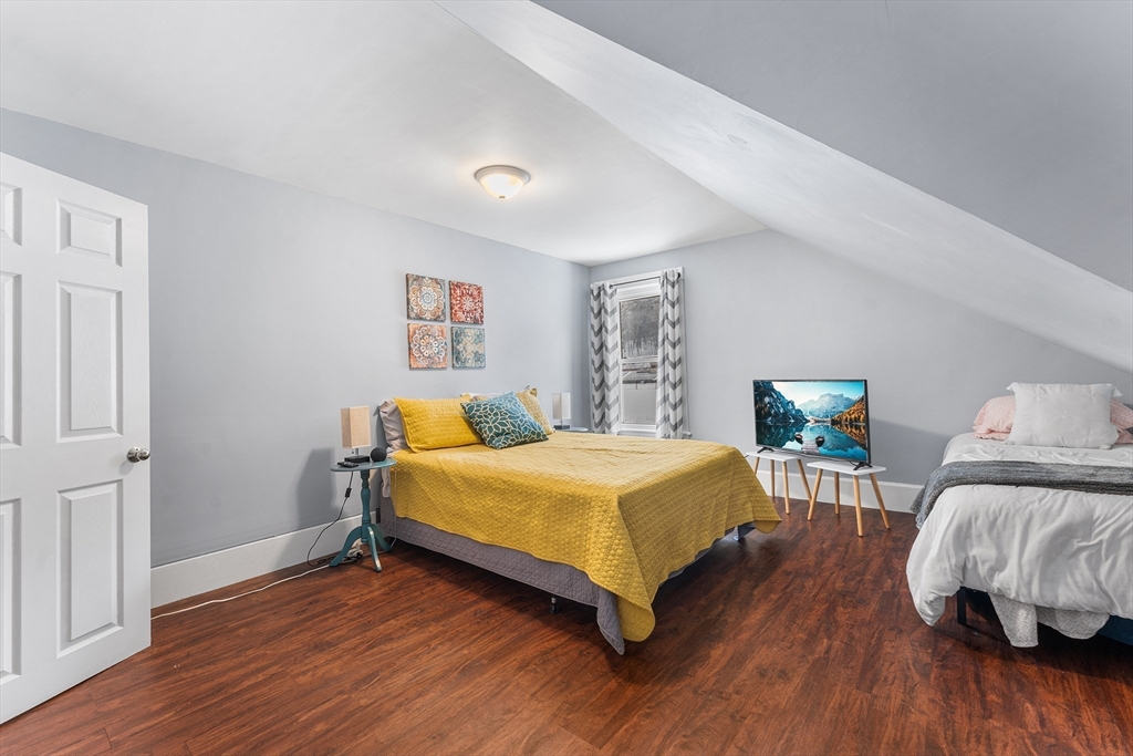 322 Highland Street Worcester, MA 01602 - Photo 22 of 29 a bedroom with a bed and wooden floor