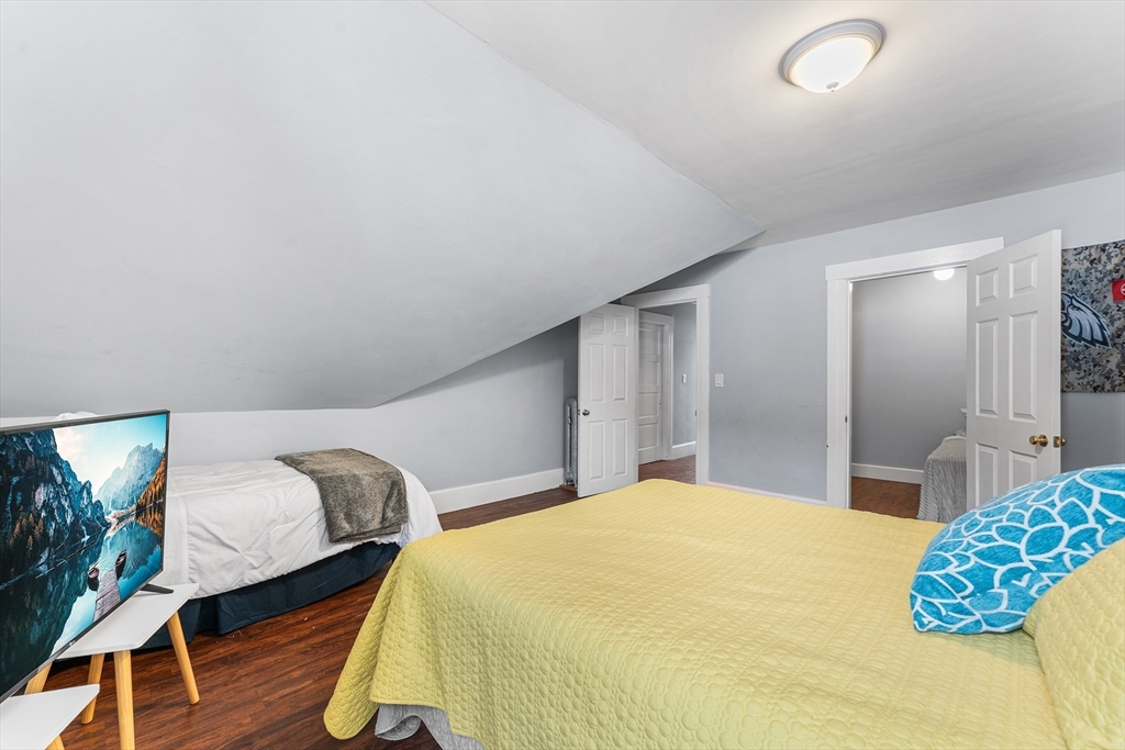 322 Highland Street Worcester, MA 01602 - Photo 23 of 29 a bedroom with a bed and wooden floor