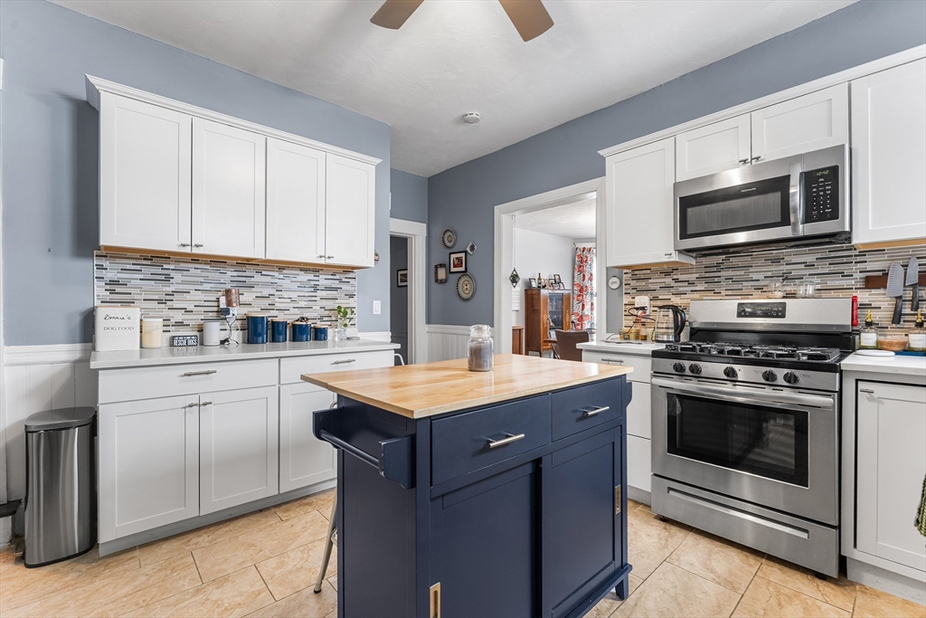 322 Highland Street Worcester, MA 01602 - Photo 10 of 29 a kitchen with stainless steel appliances granite countertop a stove top oven a sink dishwasher and a microwave oven with white cabinets