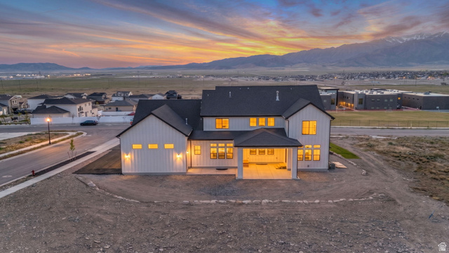 2828 Jojo Road Eagle Mountain, UT 84005 - Photo 61 of 63 Contemporary-style residence featuring white board and batten siding, a dark roof, and multiple windows
