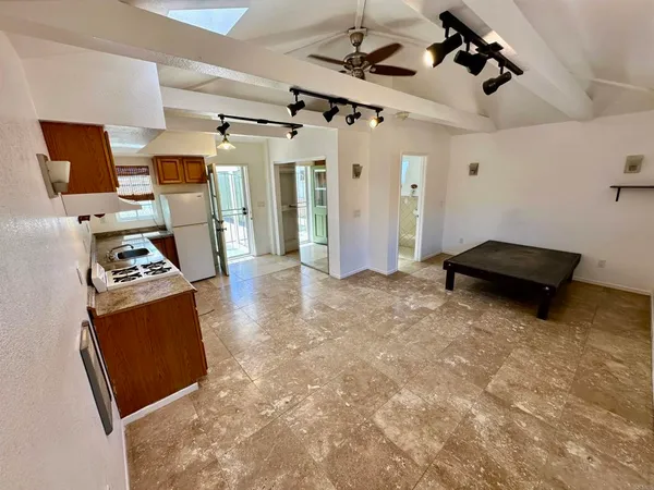 a kitchen with granite countertop a refrigerator and a stove top oven