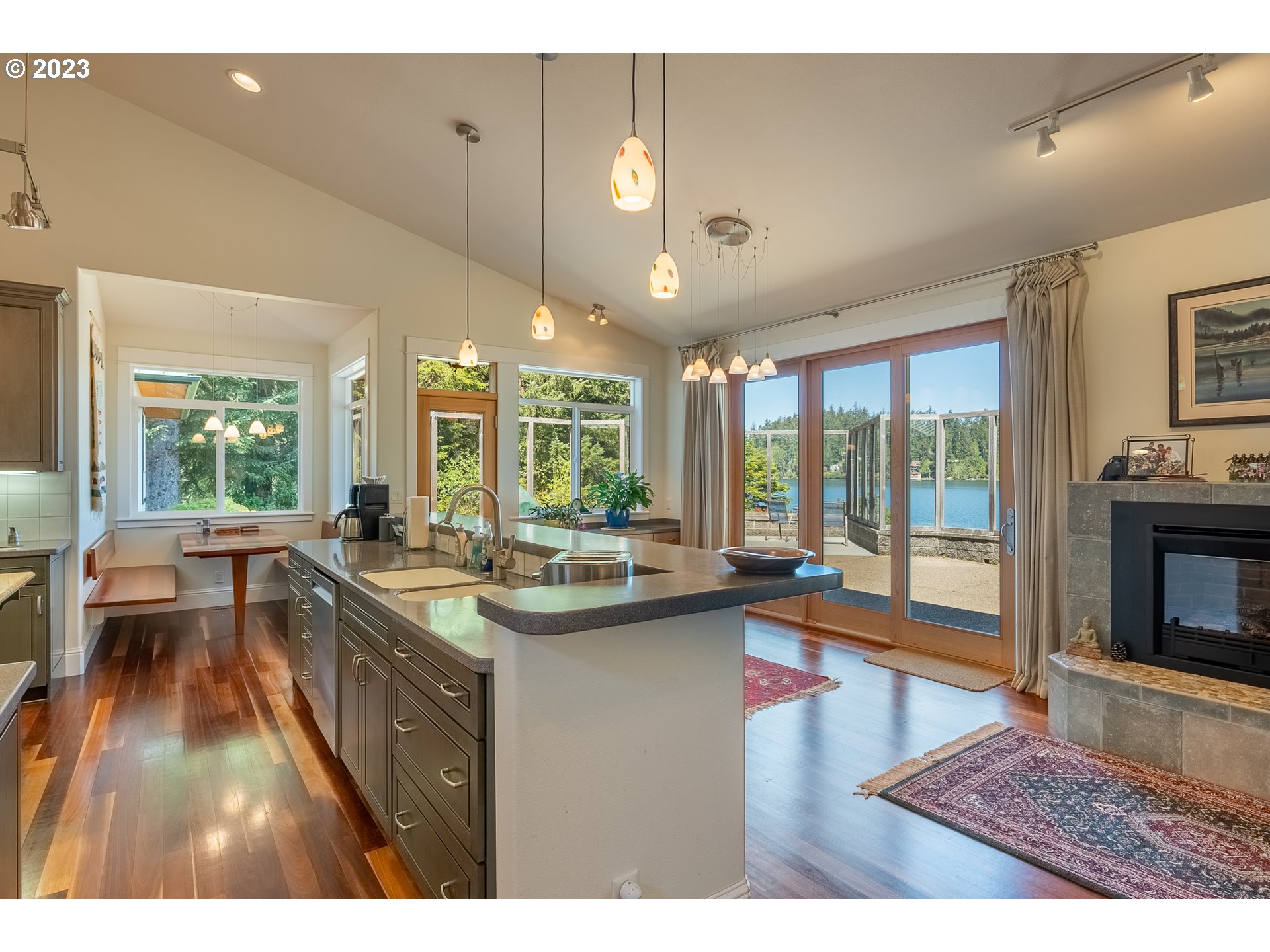 83917 Cloud 9 Road Florence, OR 97439 - Photo 13 of 48 a dining hall with stainless steel appliances granite countertop a sink dishwasher and white cabinets with wooden floor