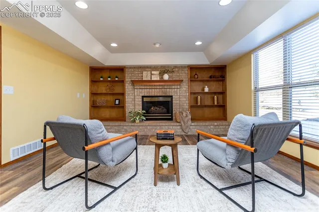 a living room with furniture a fireplace and a window