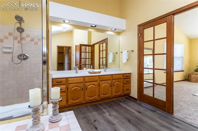 a spacious bathroom with a double vanity sink a mirror and a shower