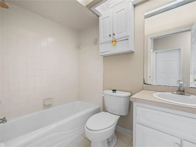 an empty room with wooden floor ceiling fan and windows