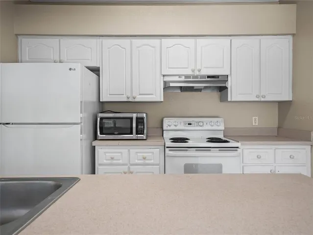 a kitchen with appliances a sink and cabinets