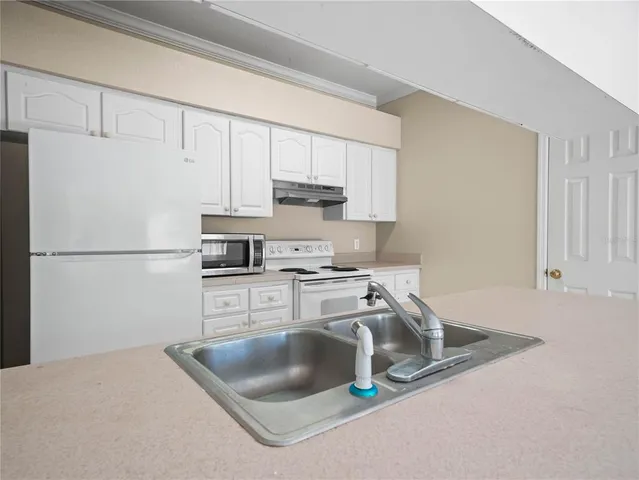 a kitchen with white cabinets and white appliances