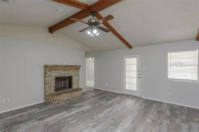 wooden floor fireplace and windows in an empty room
