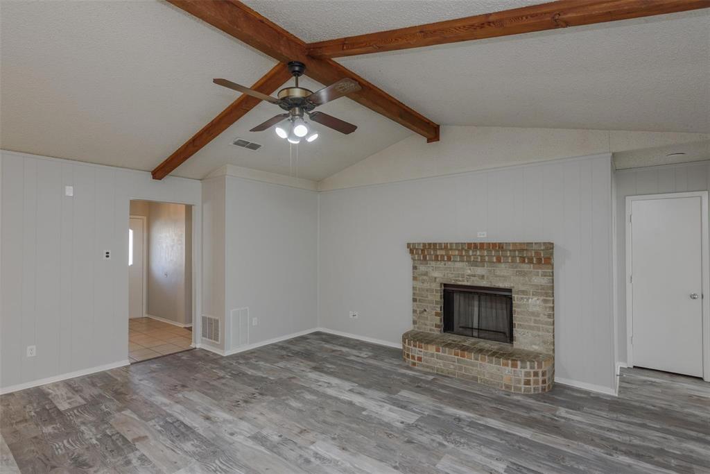 3609 Cooper Branch East Denton, TX 76209 - Photo 5 of 23 a view of an empty room with wooden floor fireplace and a window