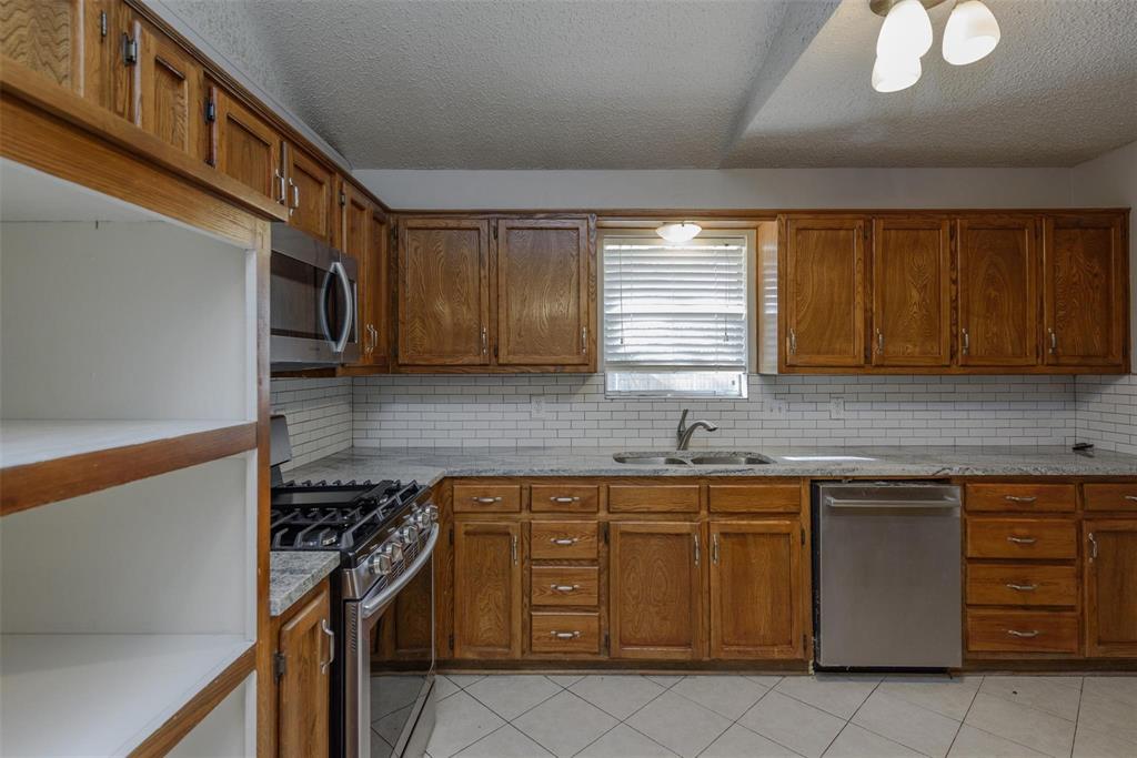 3609 Cooper Branch East Denton, TX 76209 - Photo 6 of 23 a kitchen with a stove a sink and a microwave