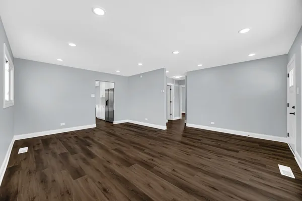 a view of an empty room with wooden floor and closet