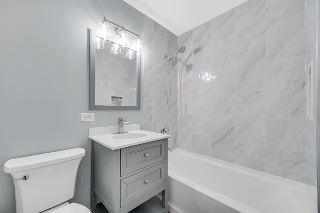 a bathroom with a sink toilet vanity and shower