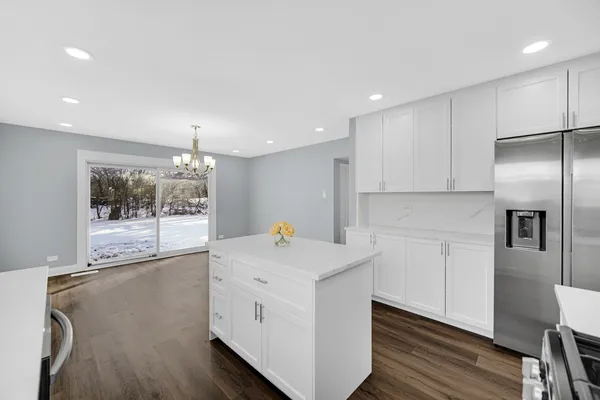 a kitchen with white cabinets and refrigerator