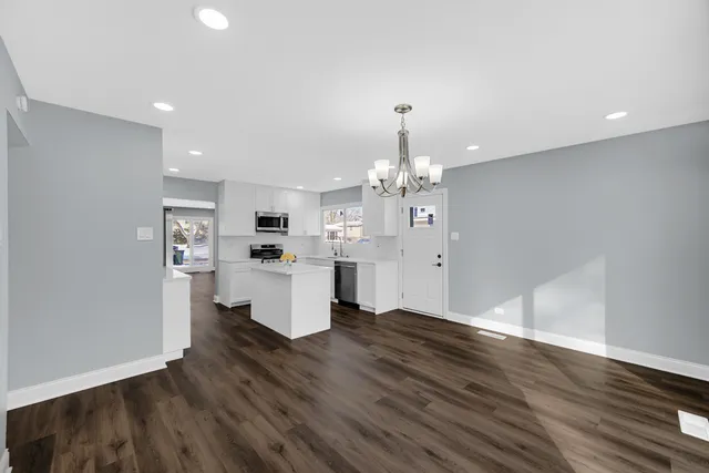 a view of a kitchen with granite countertop stove top oven and cabinets