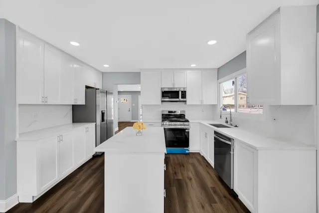 a kitchen with stainless steel appliances a stove refrigerator sink and microwave