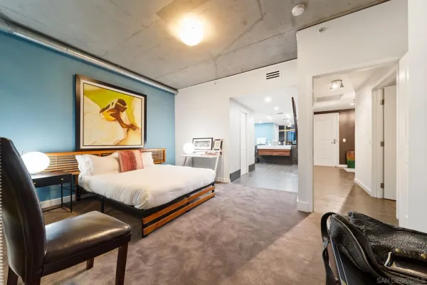 a spacious bedroom with a bed and a lamp